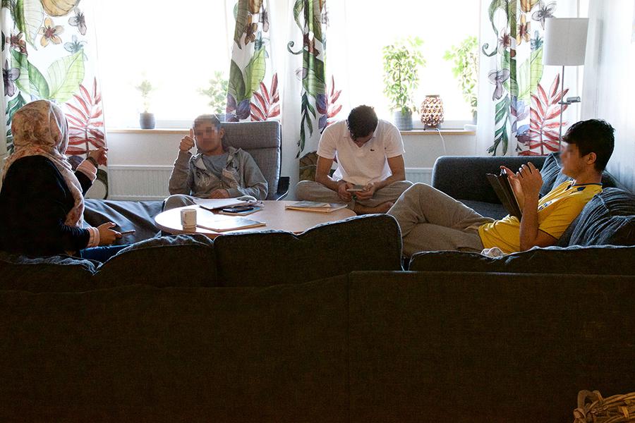 Boys sit with an interpreter in the living room at a group home for unaccompanied children in Gothenburg, Sweden. 