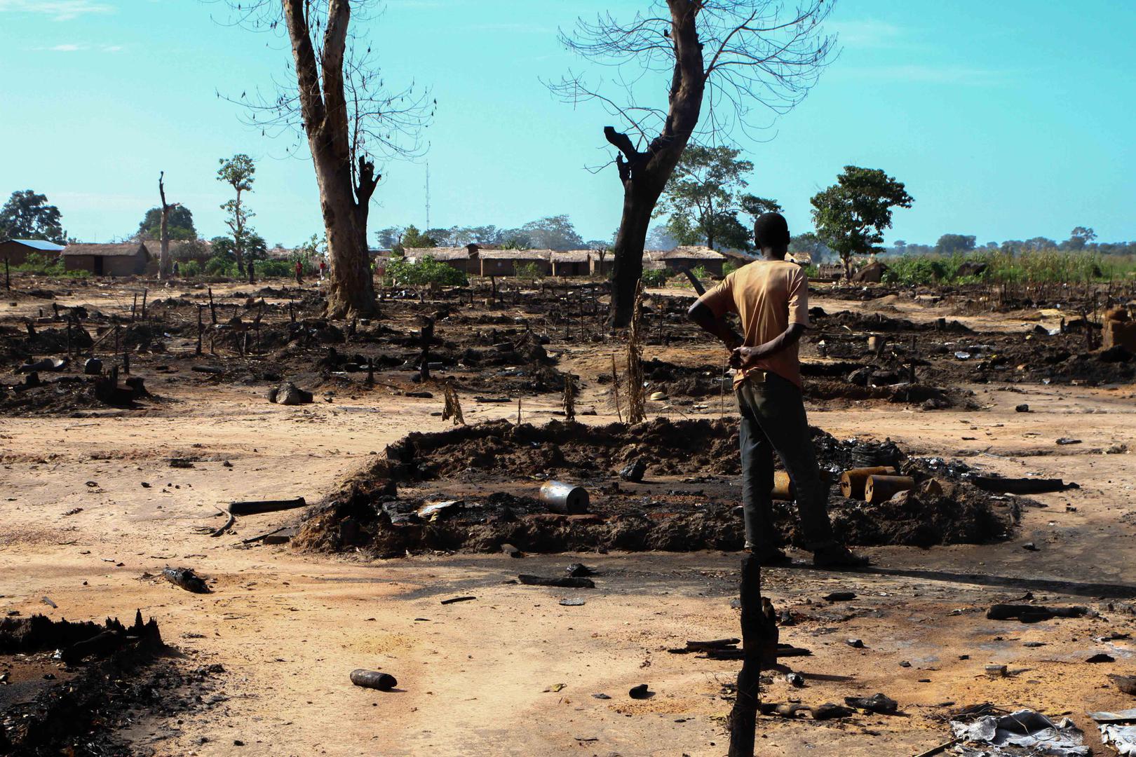 A man inspects his burned hut in L’Évêché displacement camp, Central African Republic, on October 12. Seleka forces burned at least 435 huts in the camp. 