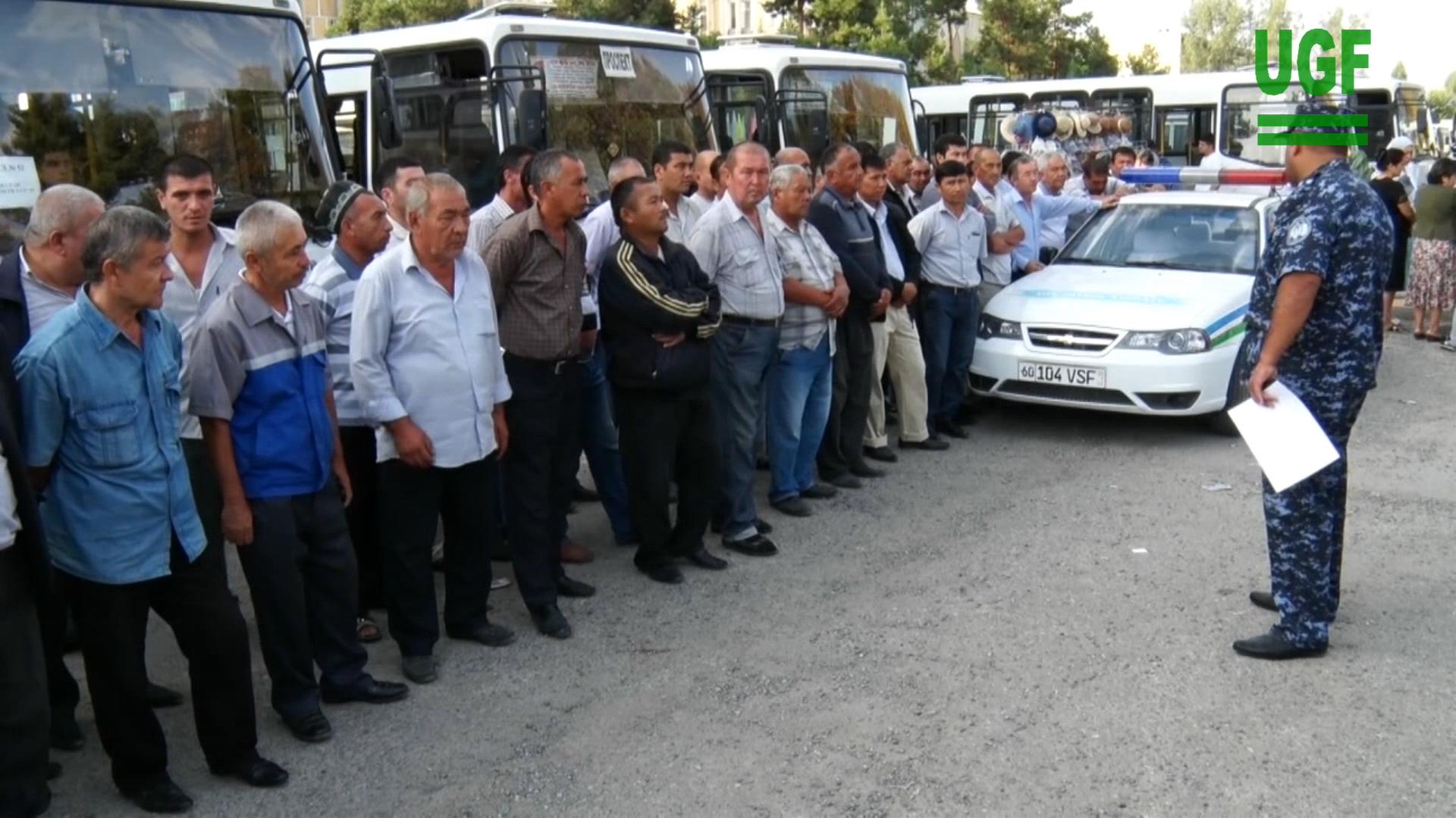 Police instructing bus drivers waiting to transport students from Andijan State University to the cotton fields, September 2015.