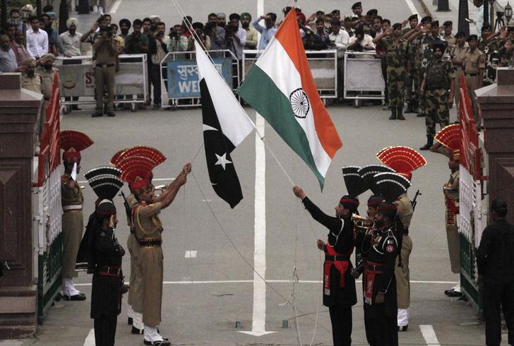 Pakistani rangers (wearing black uniforms) and Indian Border Security Force (BSF) officers lower their national flags during a daily parade at the Pakistan-India joint check-post at Wagah border, near Lahore November 3, 2014.