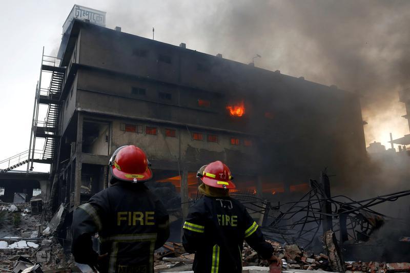 In September 2016, another factory burned in the same district. Here, firefighters stand at the site of a fire at a packaging factory outside Dhaka, Bangladesh, September 10, 2016.