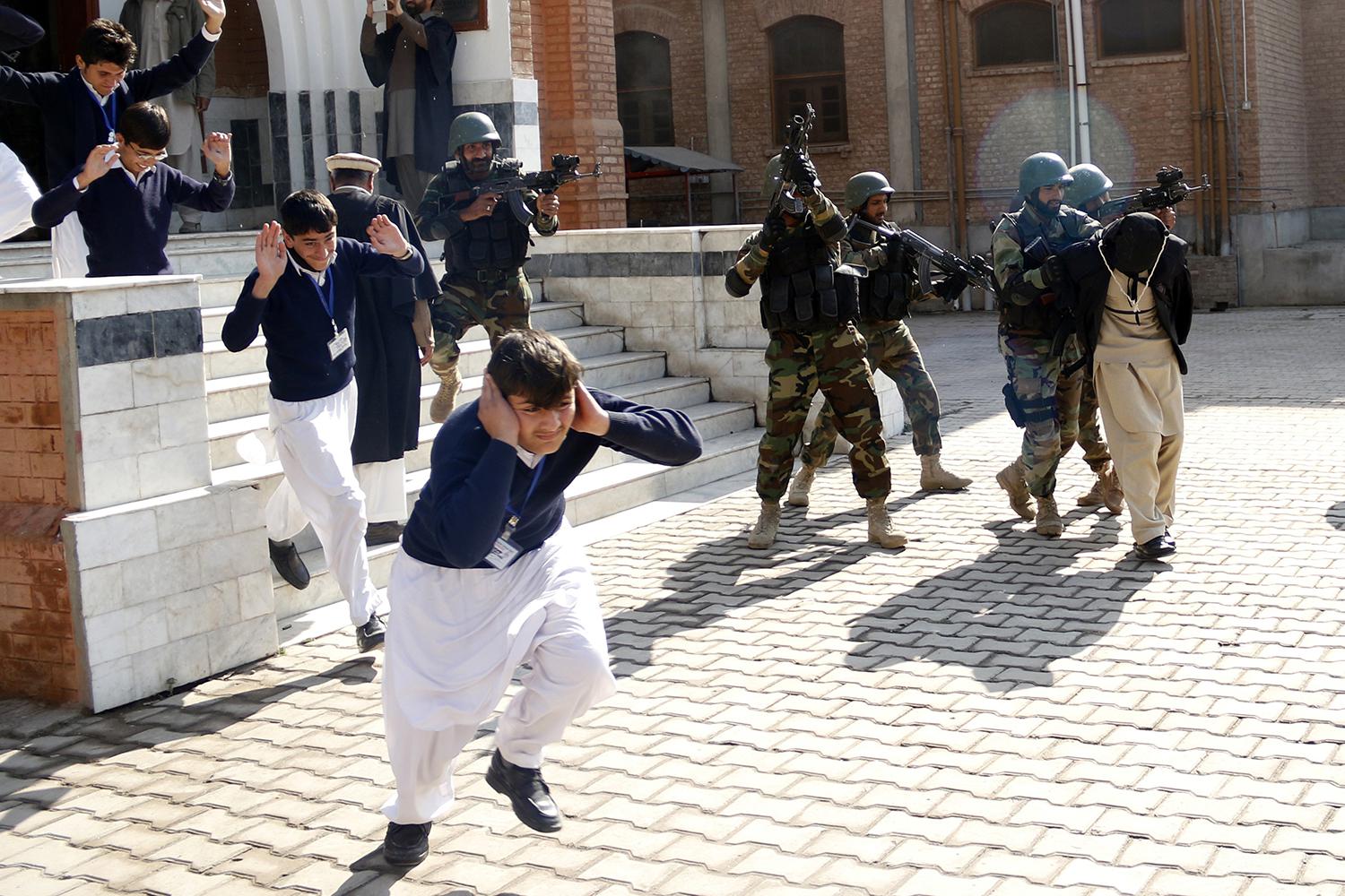 School children flee as soldiers conducting an exercise to repel militant attacks detain a mock-militant (R) at the Islamia Collegiate School in Peshawar, Pakistan, February 2016.  