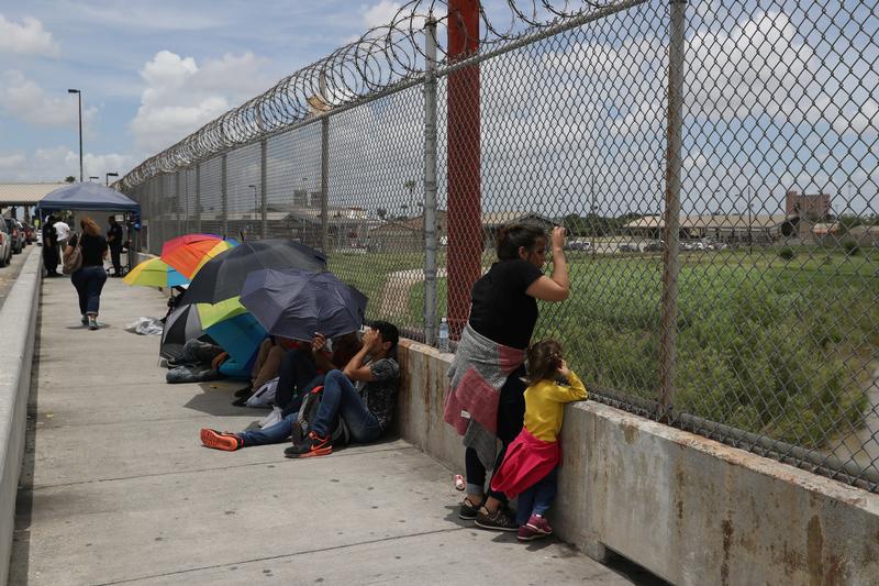 A Honduran mother and her 3-year-old daughter wait with fellow asylum seekers on the Mexican side of the Brownsville-Matamoros International Bridge after being denied entry by U.S. Customs and Border Protection officers near Brownsville, Texas, U.S., June