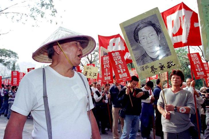 A Chinese Communist supporter (L) hurls insults to protesters as they began a march in Hong Kong January 1, calling for more democracy in China. The rally was first of a series of activities planned by pro-democracy activists in the territory to mark the 
