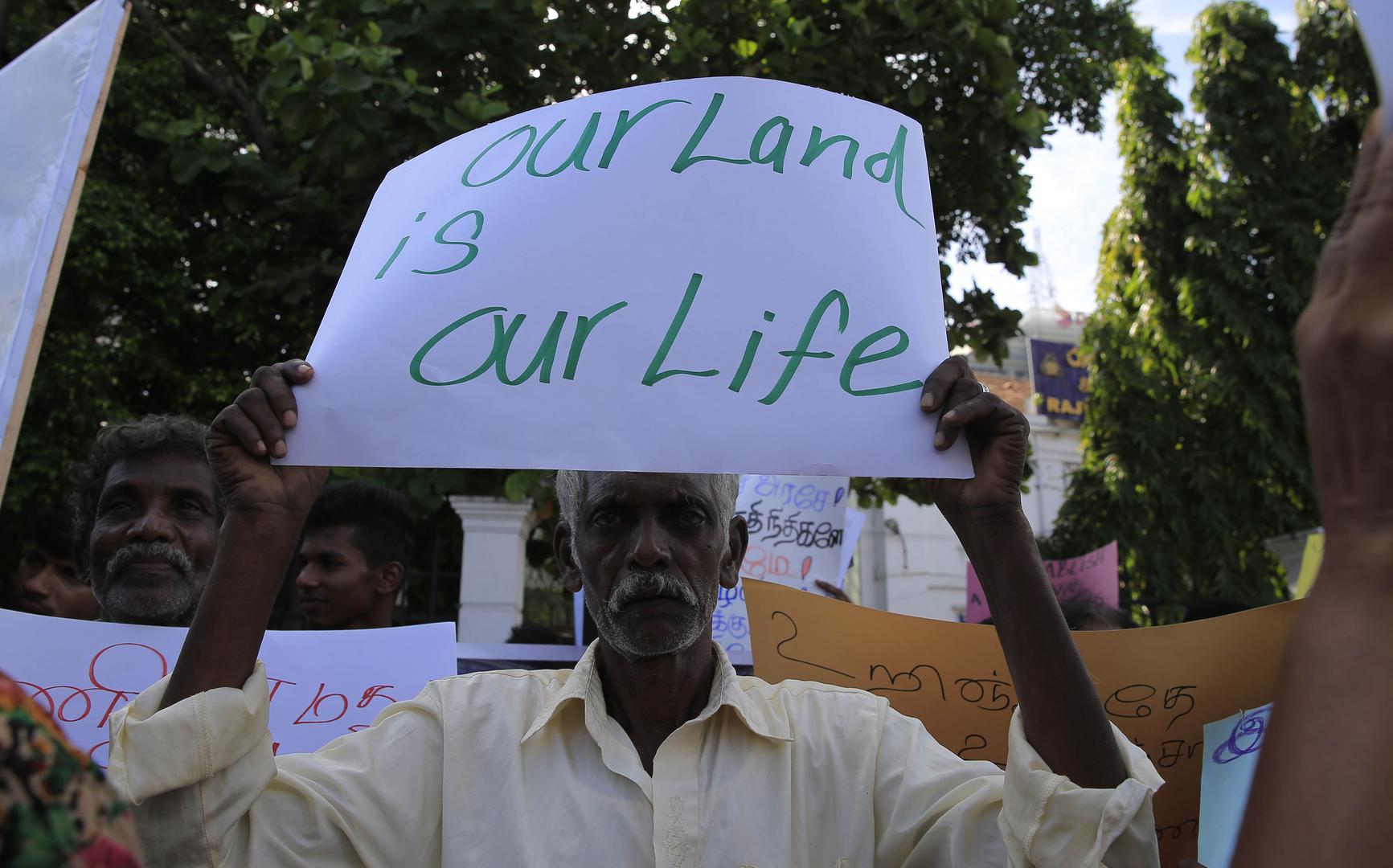  A Sri Lankan Tamil man holds a placard during a protest in Colombo on August 21, 2018, demanding the release of lands still occupied by the military. 