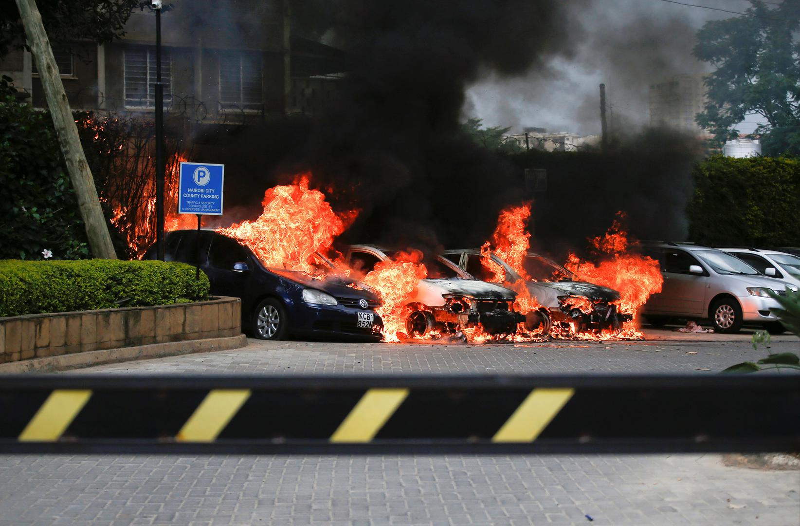 Burning cars are seen at the scene where explosions and gunshots were heard at the Dusit hotel compound, in Nairobi, Kenya January 15, 2019. 