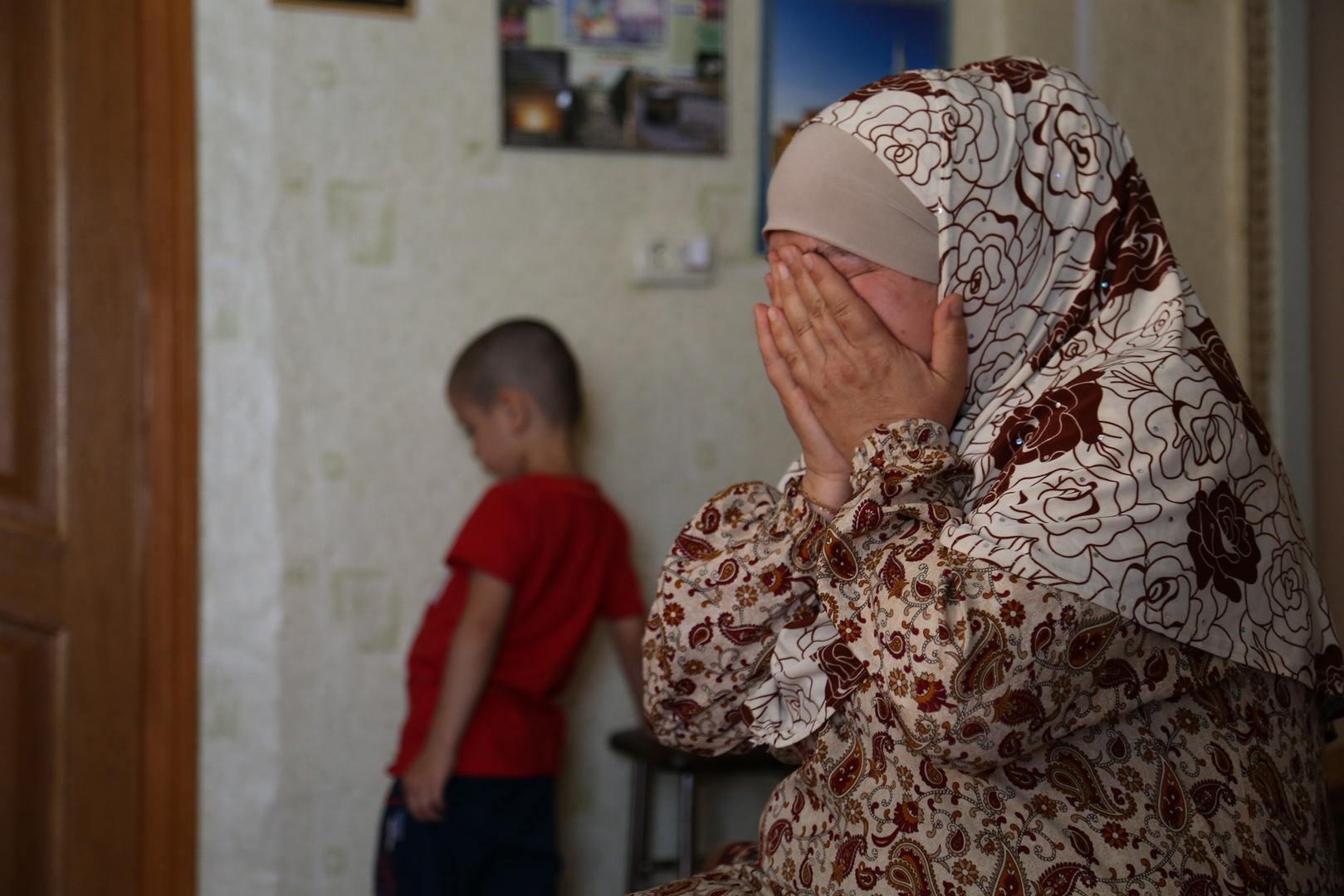 Lemara Omerova and her grandchild after the arrest of her husband, Enver Omerov, and her son and the grandchild’s father, Riza Omerov, on June 10, 2019.