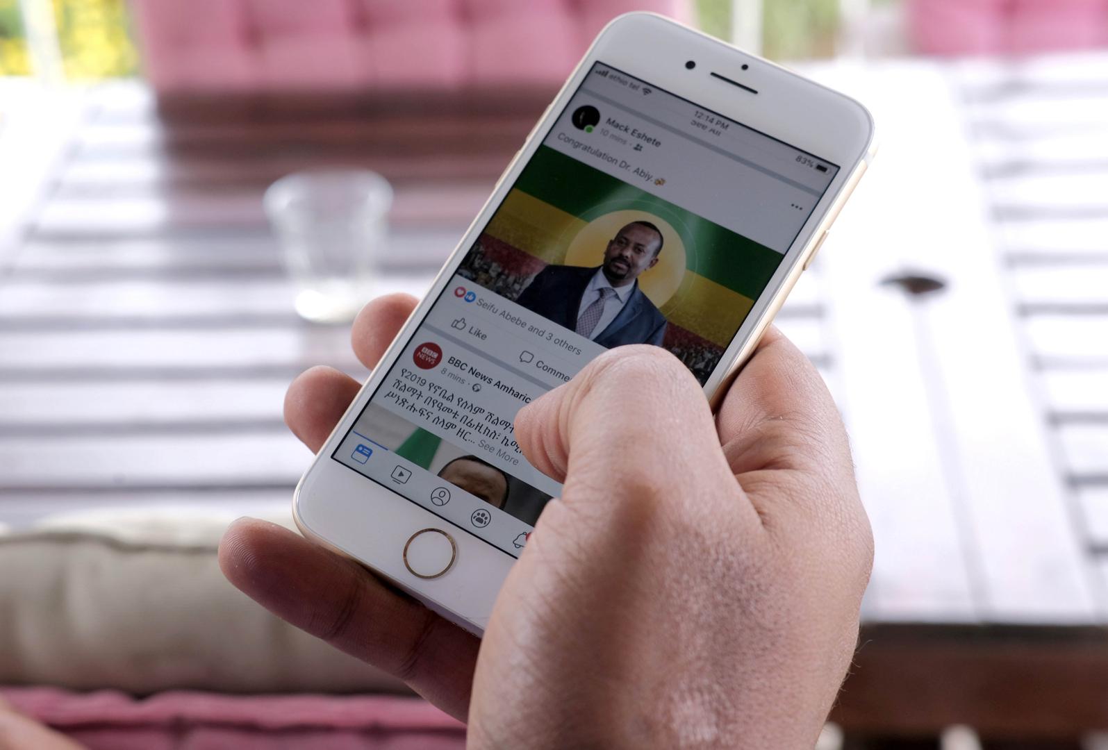 A man scrolls down his cell phone for social media newsfeed in Addis Ababa, Ethiopia October 11, 2019.