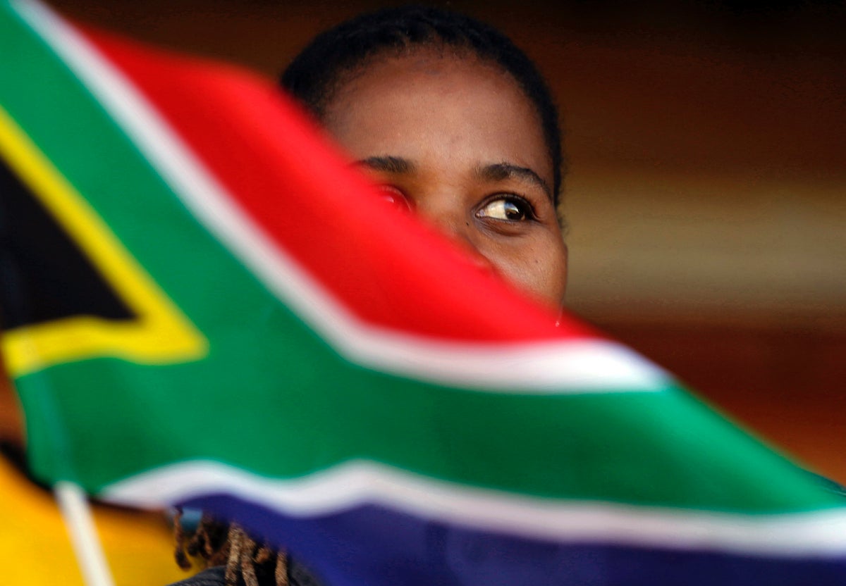 A woman waves a South African flag as she attends Freedom Day celebrations in Kwa-Thema Township, near Johannesburg