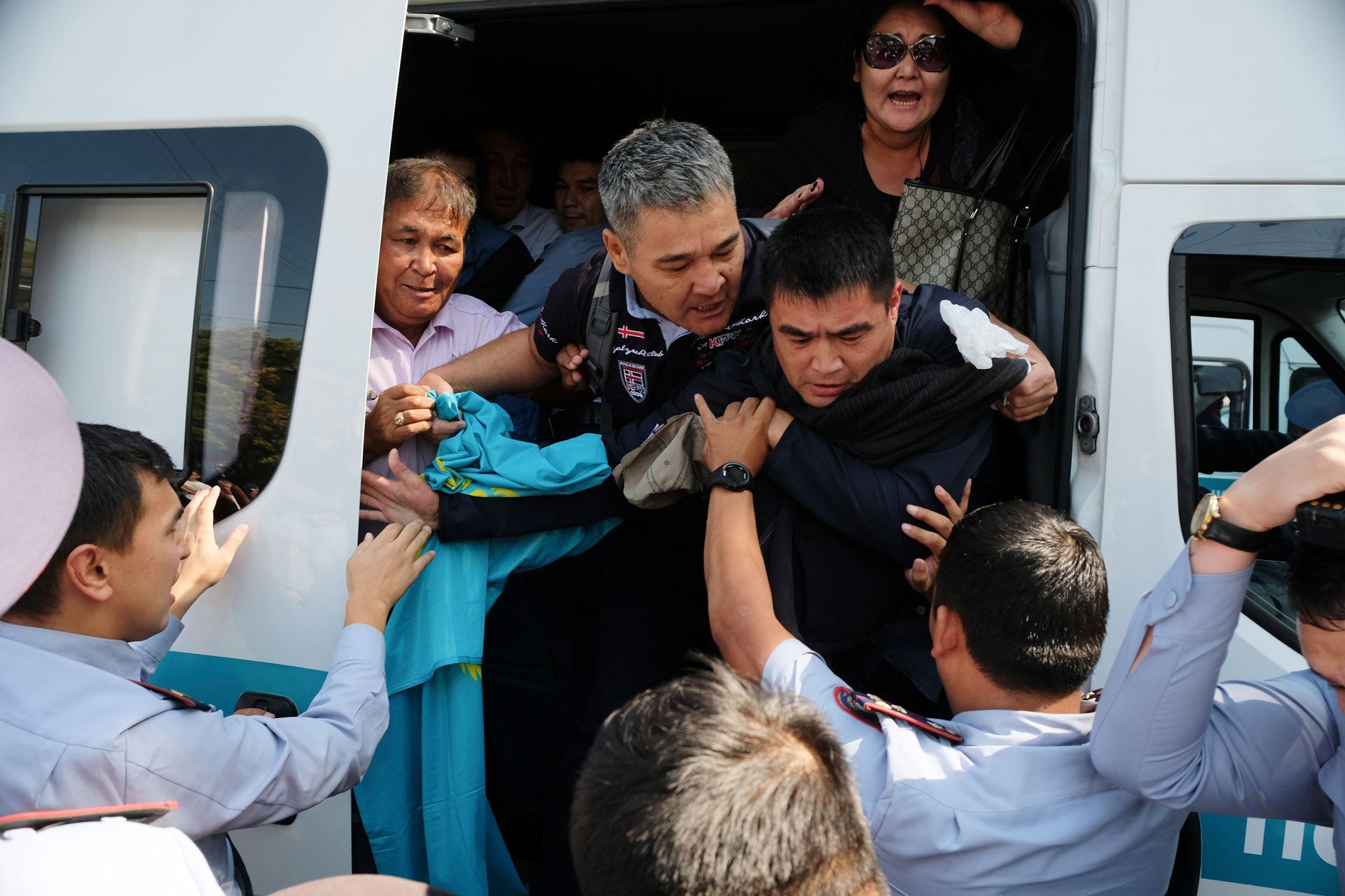 Kazakhstan's police officers push arrested protesters into a police bus during an opposition rally in Almaty, Kazakhstan, September 21, 2019. 