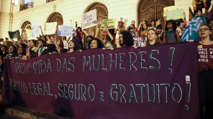 Women hold a banner calling for “legal, safe and free abortion,”