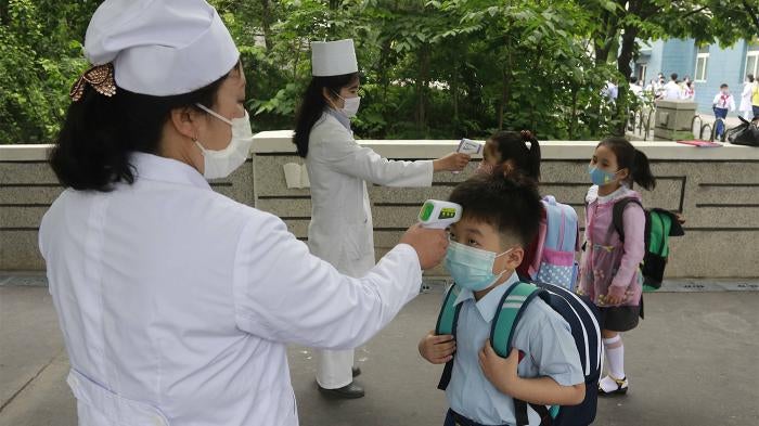 Kim Song Ju Primary school students have their temperatures checked before entering the school in Pyongyang, North Korea. 