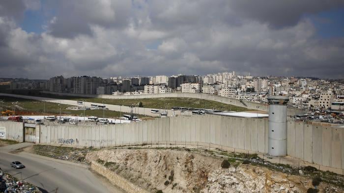 A concrete wall separates a city and a highway