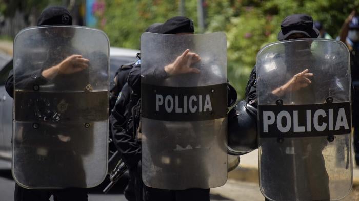 A row of police holding riot shields