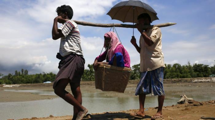 Rohingya people refugees carry an older woman on the way to camp at Shahpori Island, in Teknaf, Bangladesh on September 13, 2017. 