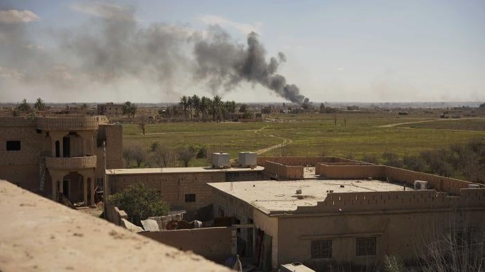 Black smoke billows from the last small piece of territory held by Islamic State forces as US-backed fighters attack the area with artillery and airstrikes in Baghouz, Syria, March 3, 2019. © 2019 AP Photo/Andrea Rosa