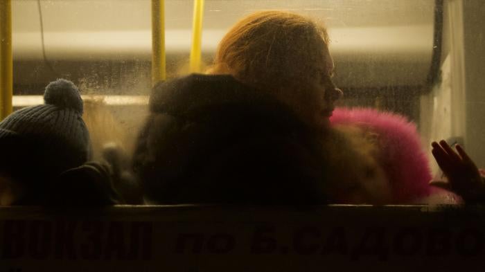 A woman and two children sitting inside a bus