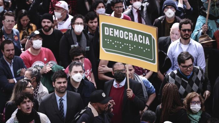 A protester holds a sign reading “Democracy” in Portuguese and in Braille at a rally in in São Paulo, August 11, 2022.