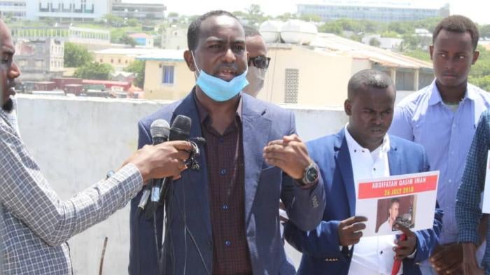 A man in speaks into a microphone