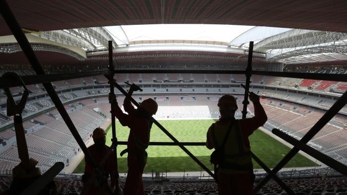 Laborers remove scaffolding at the Al Bayt stadium in Al Khor, Qatar, Monday, April 29, 2019.