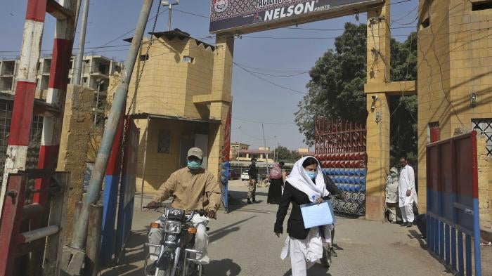 people exit the main entrance of the Karachi Central Prison