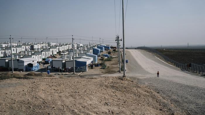 A boy walks on a road at the Mamrashan camp for civilians displaced by war, located a half hour's drive from Dohuk city in Iraq.