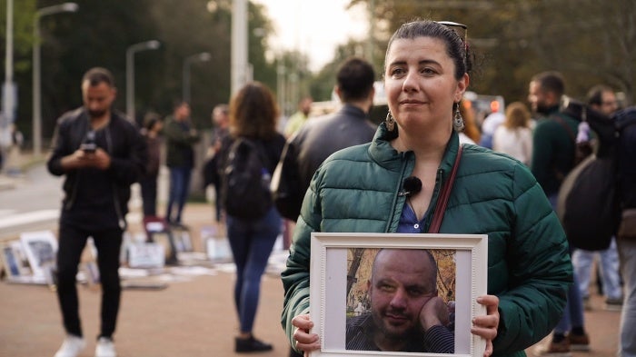 Reem Fadel holding a photo of her brother in law at the International Court of Justice in The Hague, Netherlands, on October 10, 2023.