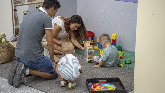 Two parents play with their children at a school in Valencia, Spain, September 12, 2022.