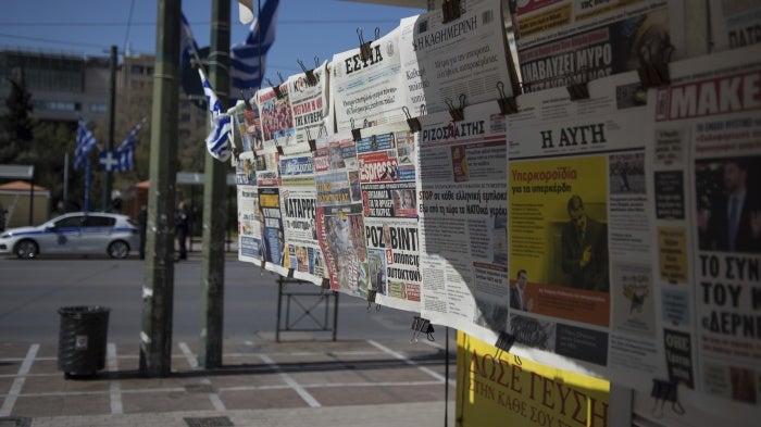 Newspapers hanging on a kiosk 