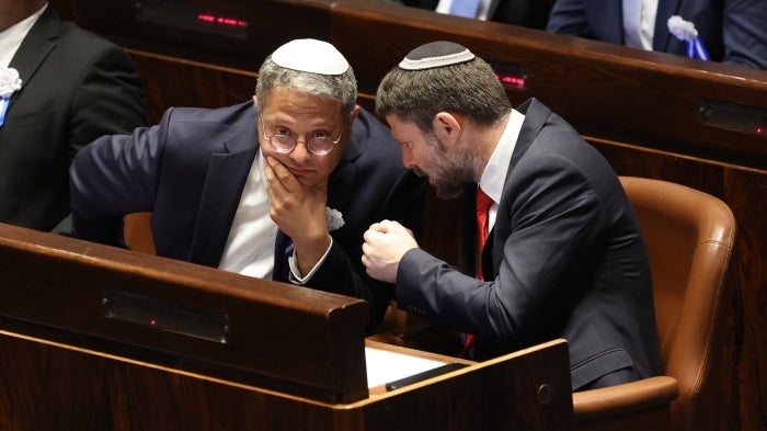 Former Israeli Knesset member and current National Security Minister Itamar Ben Gvir (R) and Minister of Finance Bezalel Smotrich speak in parliament, in Jerusalem, November 15, 2022.