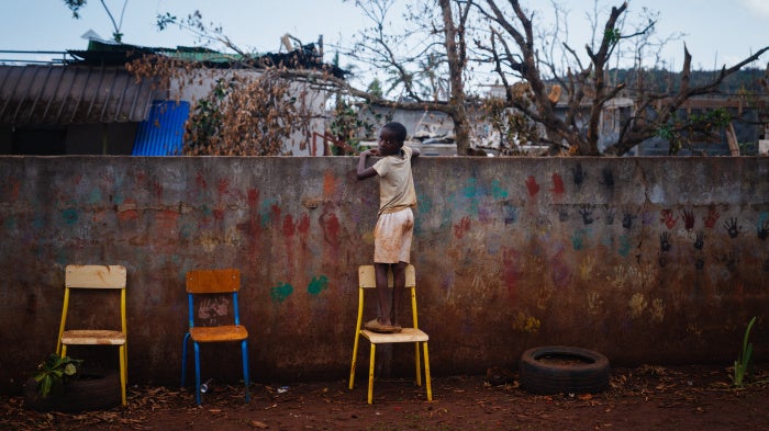 A boy looks over a school fence 