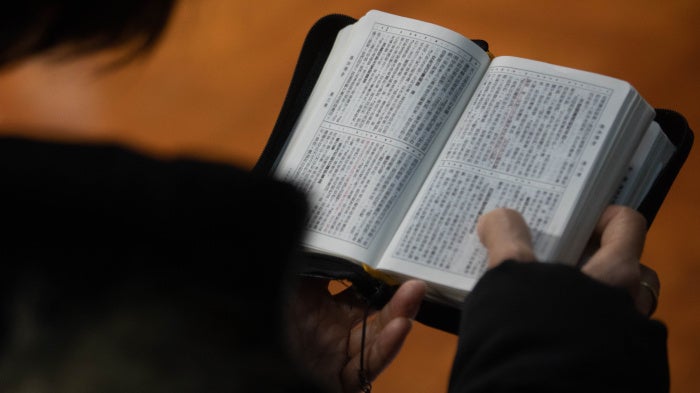 A church member reads a bible during a service in Hong Kong in solidarity with the Early Rain Covenant Church in China, whose members face persecution, December 18, 2023. 