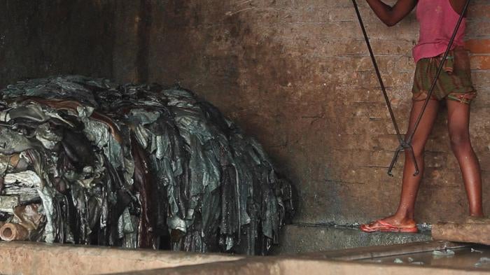 A boy soaks hides in a pit of diluted chemicals in a Hazaribagh tannery. International law binding on Bangladesh, as well as Bangladesh’s own labor law, prohibits employing children under 18 in harmful or hazardous work. Dhaka, June 2012.