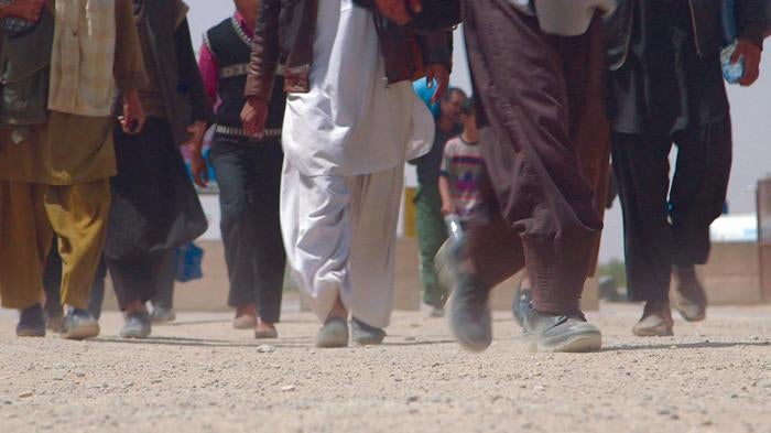 Afghans cross the border from Iran back into Afghanistan near Islam Qala, Afghanistan, in April 2013.
