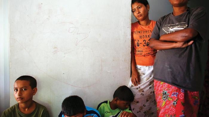 Rohingya women and children who arrived by boat from Burma pass the time at a closed shelter in Phang Nga, Thailand, in October 2013