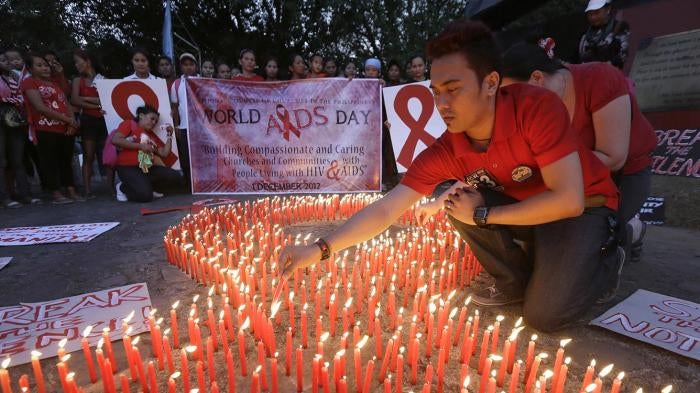 Filipinos light candles, which are shaped into an AIDS symbol, to mark World AIDS Day on December 1, 2012, in Manila, Philippines.