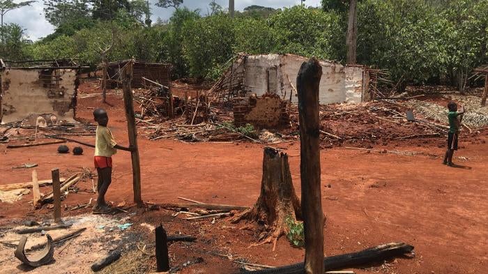 Children stand among houses burnt during an eviction operation in the protected forest of Goin-Débé, Côte d'Ivoire, in January 2016.