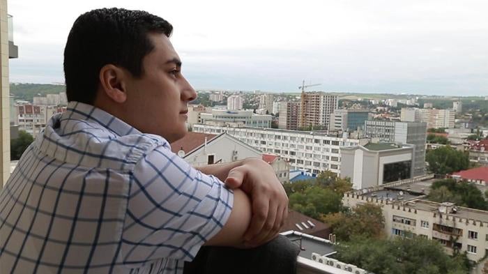Man looking out over the balcony. 