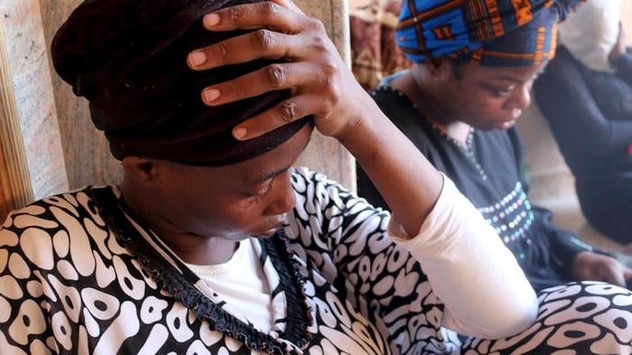 Migrants sit at a detention center in Tripoli after they were detained by the Libyan authorities on September 17, 2015.
