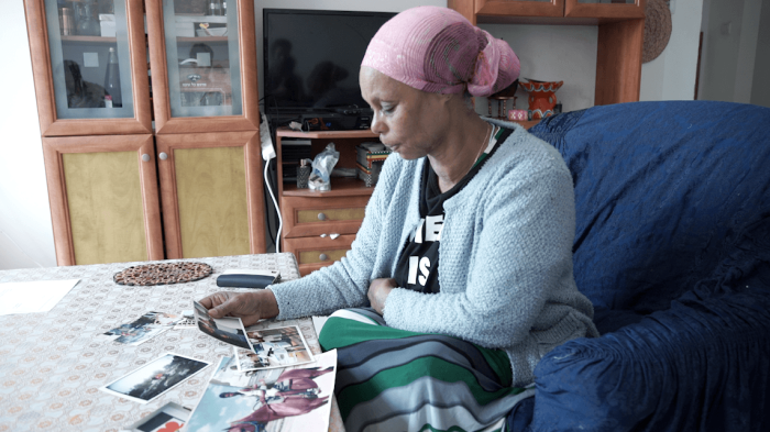 Mother looking at her missing son's photos.