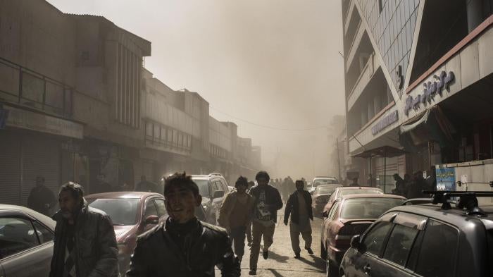 People flee after an ambulance rigged with explosives detonated in central Kabul, killing 103, January 27, 2018.