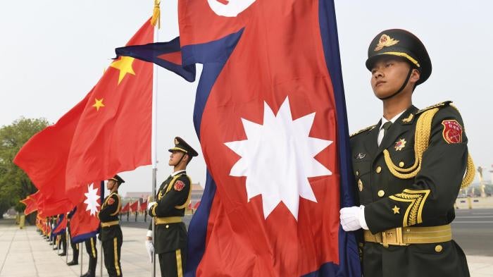 Chinese Honour Guard stand with Nepalese and Chinese flags ahead of a welcoming ceremony for the Nepalese President Bidhya Devi Bhandari