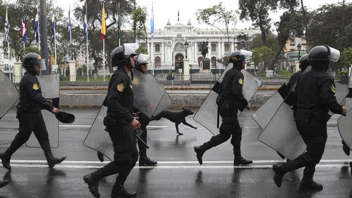 Riot police walk in front of the closed congress building in Lima, Peru, Tuesday, Oct. 1, 2019. 