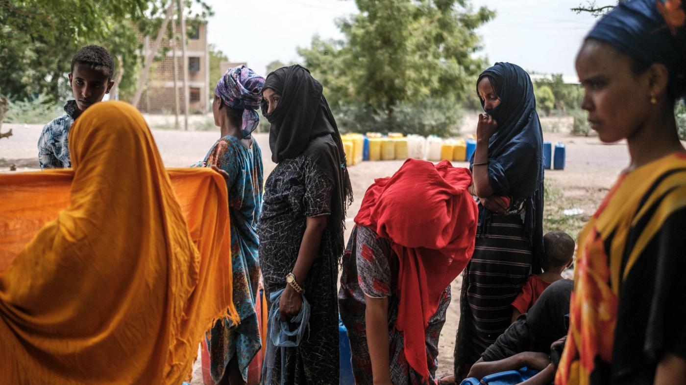  People collect water from a tank in a compound of abandoned buildings, where internally displaced people are sheltered, near the town of Dubti, in the Afar region of northern Ethiopia, June 7, 2022.
 © 2022 Eduardo Soteras/AFP/Getty Images