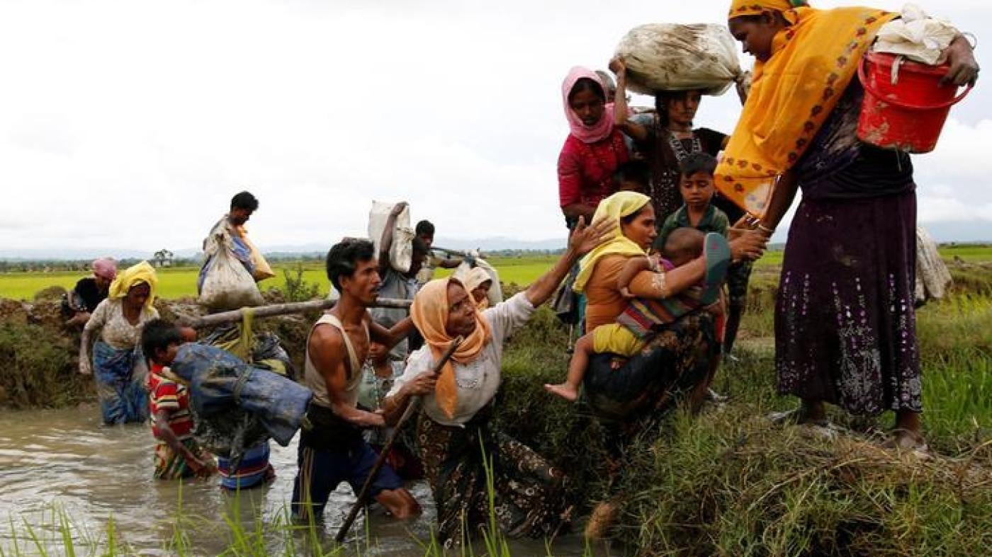 A group of Rohingya refugees cross a canal after travelling over the Bangladesh-Burma border in Teknaf, Bangladesh, September 1, 2017.