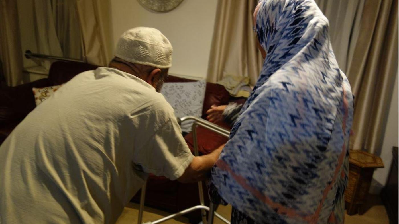 Farhaz is helped from his bed to the living room by his wife Barsha.  © 2018 Stephanie Hancock/Human Rights Watch