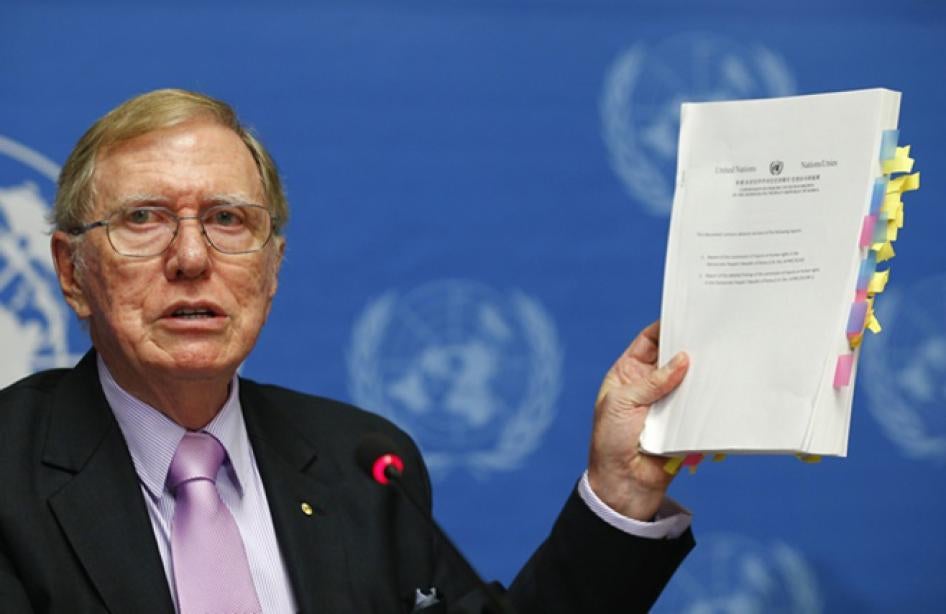 2014년 2 월 17 일 마이클 커비 전 북한 인권 조사 위원회의 위원장은  제네바 유엔에서 기자 회견 동안 보고서 사본을 들고있다. 