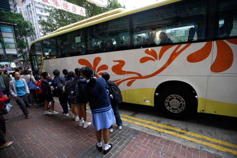 Children wait for a school bus in Hong Kong, November 20, 2019.