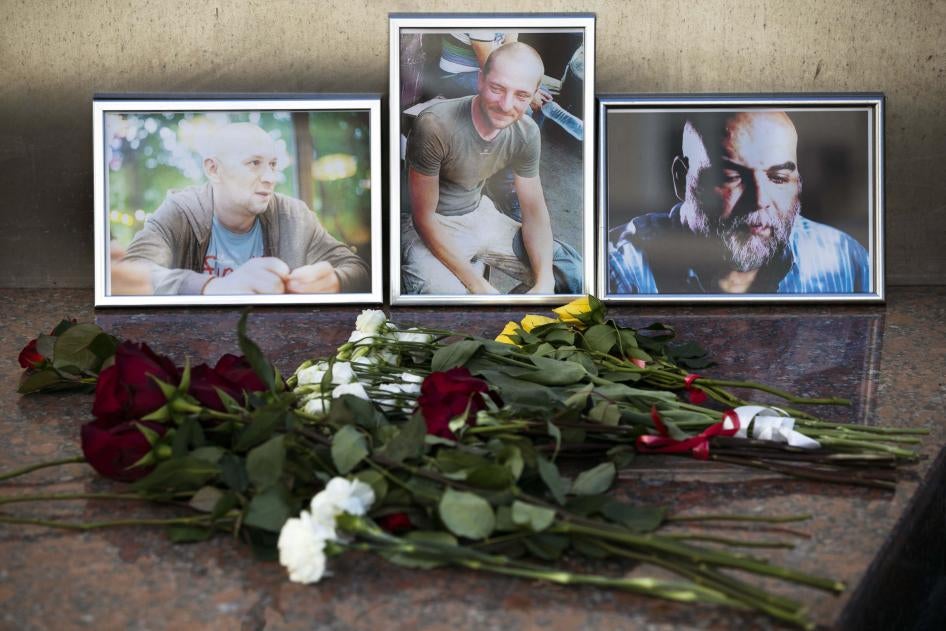 Flowers are placed by portraits of slain journalists Alexander Rastorguyev, Kirill Radchenko, and Orkhan Dzhemal, at the Russian Journalists’ Union building in Moscow on August 1, 2018.