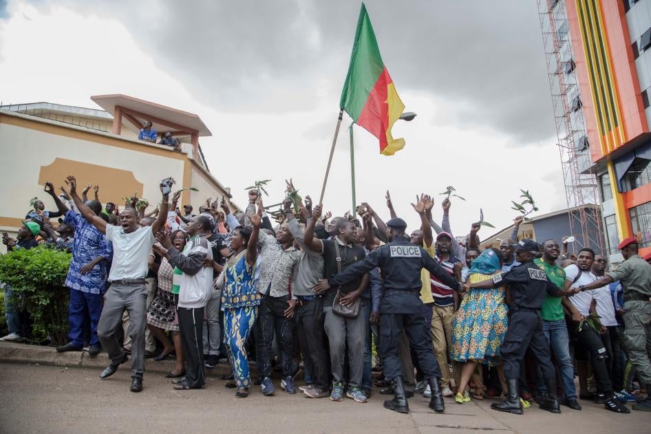 Hundreds of supporters raise their arms and wave the national flag while waiting to greet Cameroonian opposition leader Maurice Kamto in Yaoundé on October 5, 2019, the day of his release from prison.